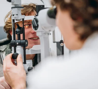Patient undergoing an eye exam with a slit lamp to check for digital eye strain and other vision issues.